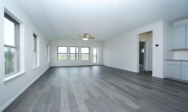 unfurnished living room featuring vaulted ceiling, dark hardwood / wood-style floors, and ceiling fan