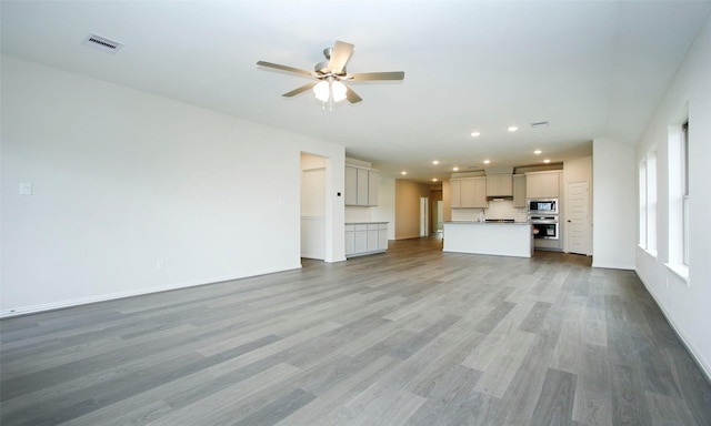 unfurnished living room with wood-type flooring and ceiling fan