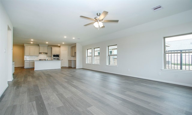 unfurnished living room featuring ceiling fan and hardwood / wood-style floors