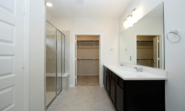 bathroom featuring tile patterned flooring, vanity, and walk in shower