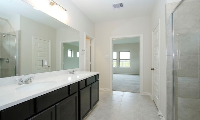 bathroom with tile patterned floors, vanity, and an enclosed shower