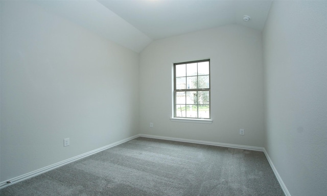 carpeted spare room with lofted ceiling