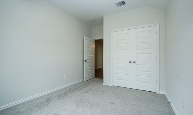 unfurnished bedroom with light colored carpet and a closet