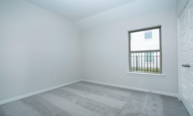 spare room featuring lofted ceiling and carpet floors