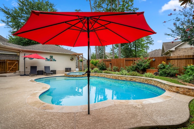 view of swimming pool featuring a patio area and an in ground hot tub