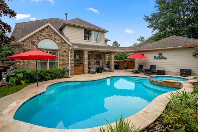 view of swimming pool featuring a patio area and an in ground hot tub