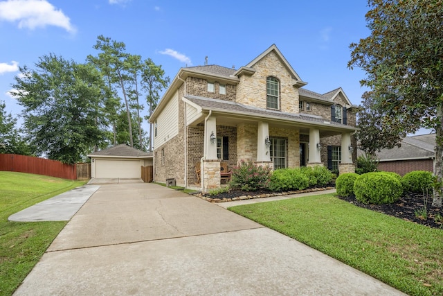 view of front of house featuring a garage, an outdoor structure, covered porch, and a front yard