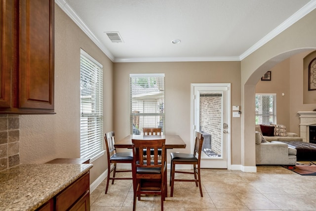 tiled dining room featuring ornamental molding