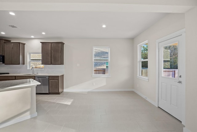 kitchen with dishwasher, light tile patterned flooring, dark brown cabinets, and sink