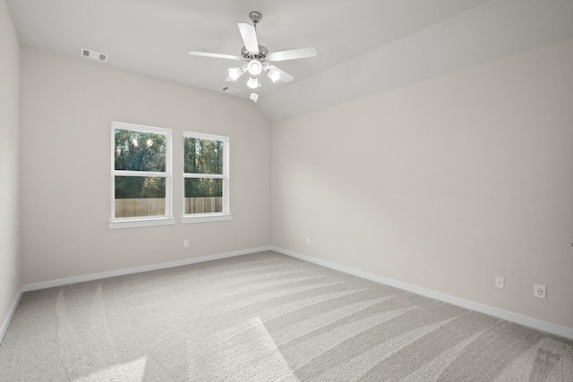 carpeted spare room featuring ceiling fan and vaulted ceiling