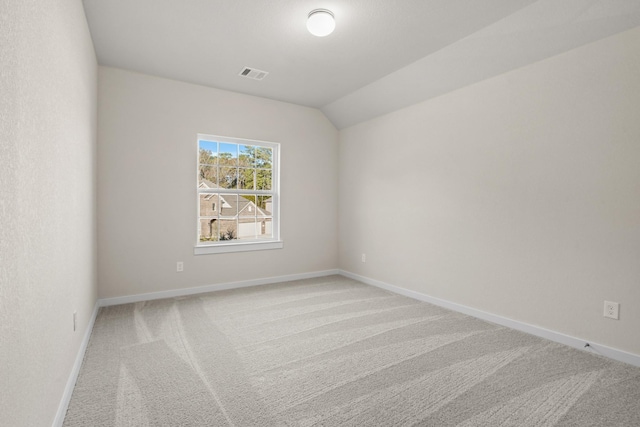 carpeted empty room with lofted ceiling