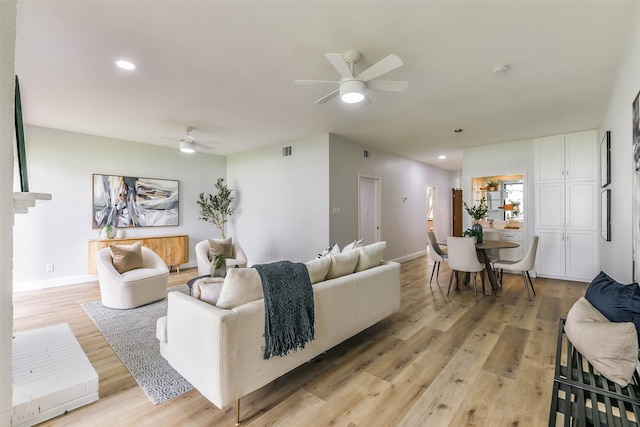 living room with light hardwood / wood-style flooring and ceiling fan