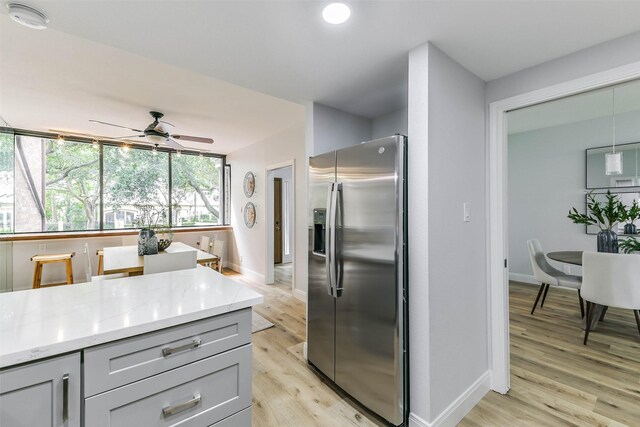 kitchen featuring gray cabinets, light hardwood / wood-style flooring, stainless steel refrigerator with ice dispenser, and ceiling fan