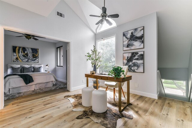 home office with high vaulted ceiling, light hardwood / wood-style flooring, and ceiling fan