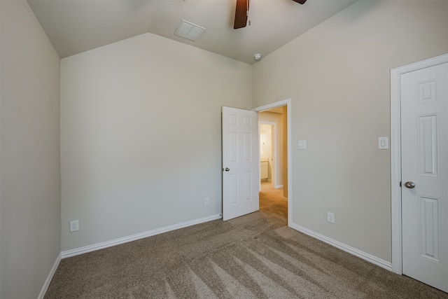 carpeted spare room with vaulted ceiling and ceiling fan