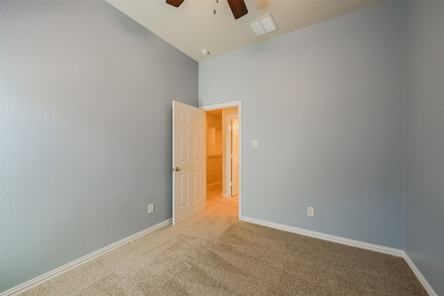 carpeted empty room featuring vaulted ceiling and ceiling fan