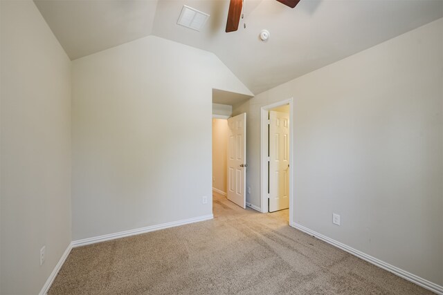 carpeted spare room featuring vaulted ceiling and ceiling fan