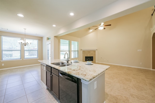 kitchen with sink, dishwasher, a kitchen island with sink, hanging light fixtures, and a fireplace