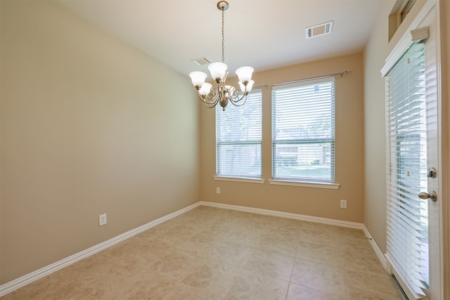 spare room featuring light tile patterned floors and an inviting chandelier