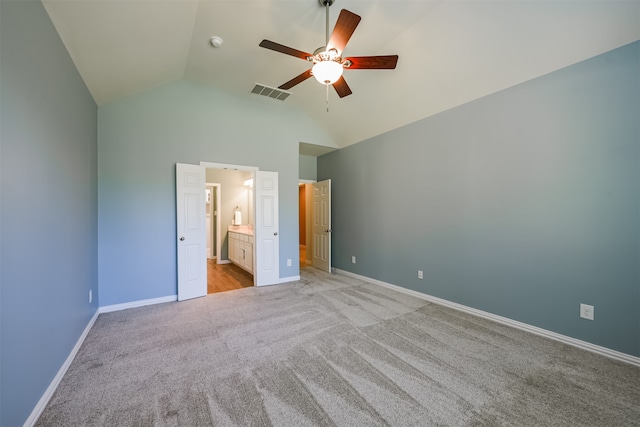 unfurnished bedroom featuring light carpet, connected bathroom, high vaulted ceiling, and ceiling fan