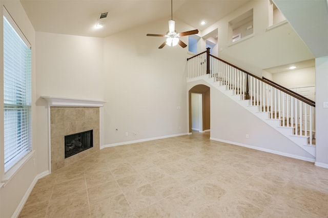 unfurnished living room featuring high vaulted ceiling, a tile fireplace, and ceiling fan