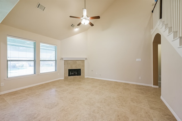 unfurnished living room featuring a fireplace, high vaulted ceiling, and ceiling fan