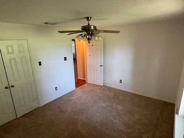 unfurnished bedroom featuring dark colored carpet and ceiling fan