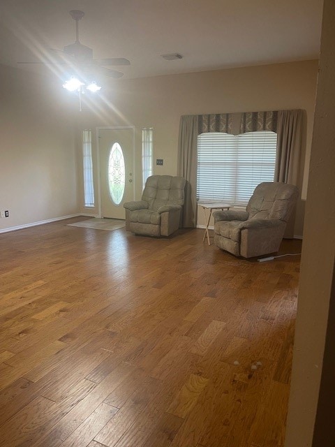 unfurnished living room with wood-type flooring and ceiling fan