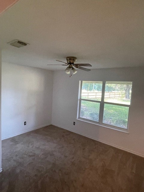 empty room featuring dark colored carpet and ceiling fan