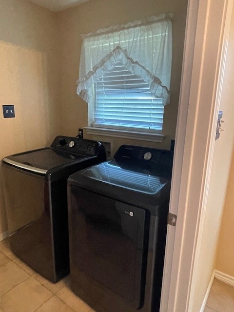 laundry area with light tile patterned floors and washing machine and clothes dryer