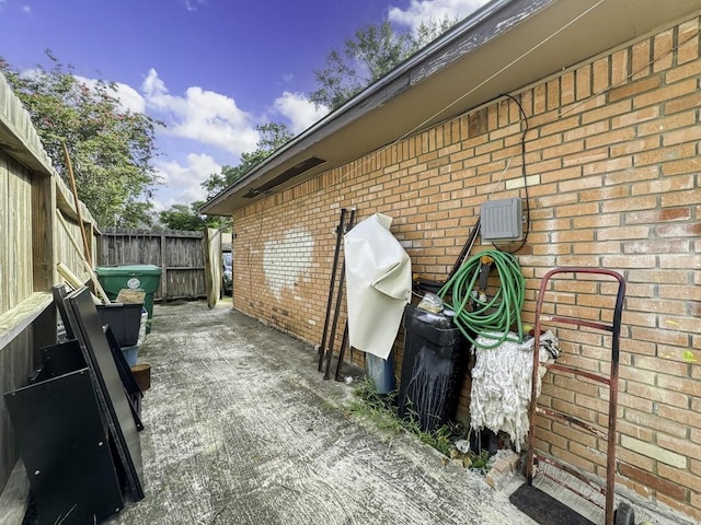 view of home's exterior featuring brick siding and fence