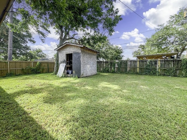 view of yard featuring a storage shed, a fenced backyard, and an outdoor structure