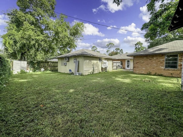 view of yard featuring an outbuilding, a wall mounted air conditioner, and a fenced backyard