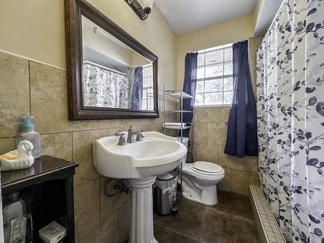 full bathroom with a shower with shower curtain, a sink, tile walls, and toilet