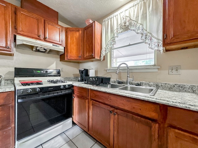 kitchen featuring light tile patterned floors, a textured ceiling, sink, and gas range gas stove