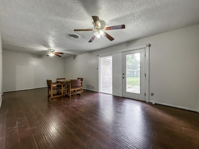 unfurnished dining area with wood-type flooring, visible vents, ceiling fan, and baseboards