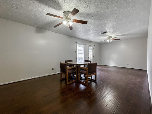 dining area featuring a textured ceiling, ceiling fan, dark wood-type flooring, and baseboards