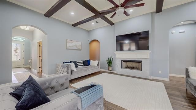 living room featuring beamed ceiling, coffered ceiling, hardwood / wood-style floors, and ceiling fan