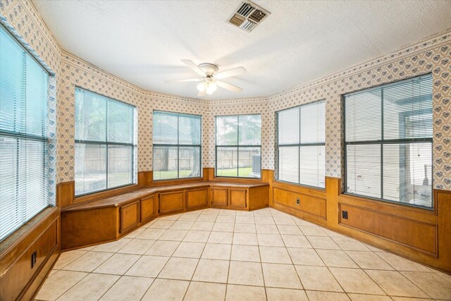 unfurnished sunroom with ceiling fan