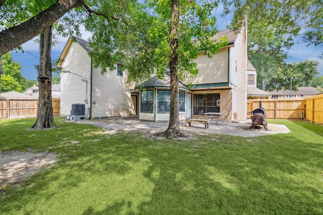 rear view of property featuring a patio, a yard, a fenced backyard, and central air condition unit