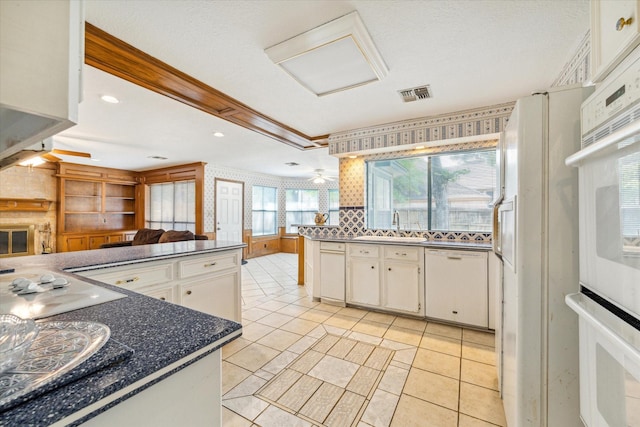 kitchen with visible vents, white cabinets, open floor plan, dishwasher, and dark countertops