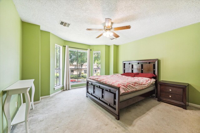 carpeted bedroom featuring a textured ceiling and ceiling fan