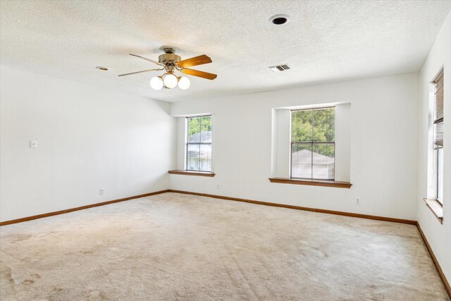 unfurnished room featuring carpet, a wealth of natural light, and ceiling fan