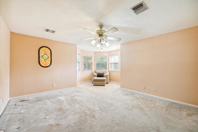 unfurnished room with visible vents, ceiling fan, light carpet, and baseboards