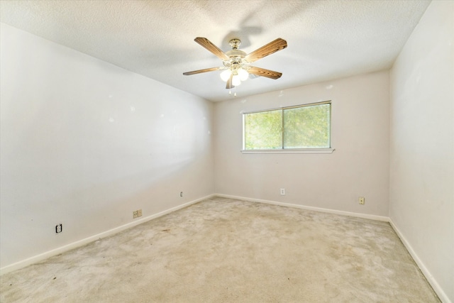 spare room featuring a textured ceiling, carpet, and ceiling fan