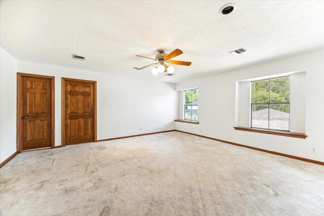 unfurnished room with carpet, a wealth of natural light, and ceiling fan