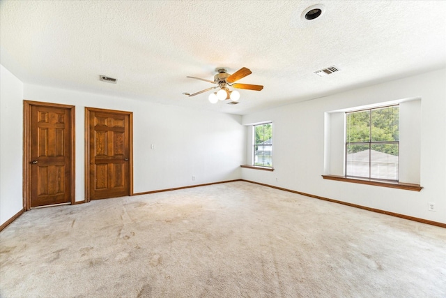 unfurnished room with visible vents, light carpet, and baseboards