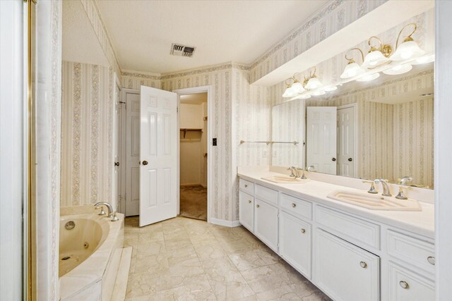 bathroom featuring tiled bath, tile patterned floors, and dual bowl vanity