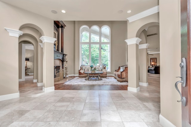 foyer featuring light hardwood / wood-style floors, ornamental molding, and decorative columns