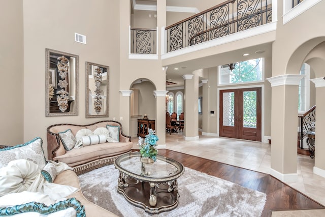 living room featuring a high ceiling, hardwood / wood-style flooring, and ornate columns